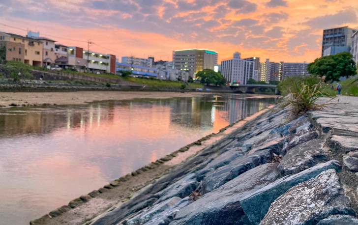 【博多区美野島】「美野島３丁目」の、夕暮れが美しい無名ロケーション 那珂川。中央の建物はワンダーランド